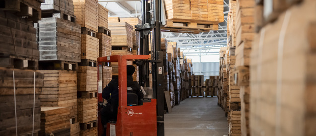 Bild på truck som lyfter låder med borrkärnor i en lagerlokal.