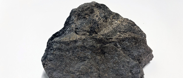 Bilden visar en stuff av en nickelmineralisering mot vit bakgrund.