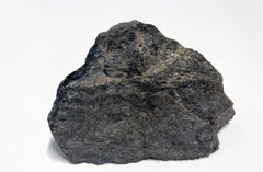 Bilden visar en stuff av en nickelmineralisering mot vit bakgrund.