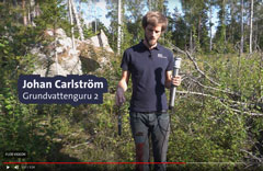 En person står i en skog. Text: "Johan Carlström. Grundvattenguru 2". Foto.