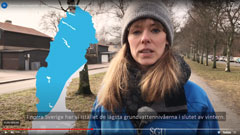 En karta över Sverige. En person med varma kläder. I bakgrunden syns ett hus. Foto.