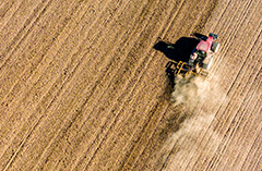 Bild på traktor som kör på åker.