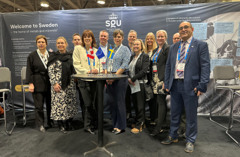 Picture showing SGU's personel together with the Embassy of Sweden and state secretary Sara Modig in front of the booth at PDAC.
