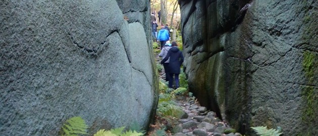 Två personer passerar genom en djup bergsklyfta. Foto. Två personer passerar genom en djup bergsklyfta. Foto.