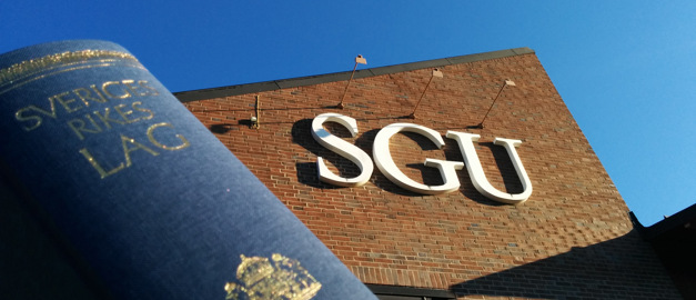 Foto av en lagbok med SGU:s byggnad i bakgrunden. Foto av en lagbok med SGU:s byggnad i bakgrunden.