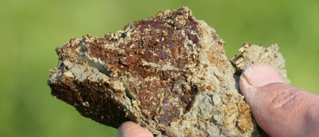 En hand som håller i sur sulfatjord. Foto. En hand som håller i sur sulfatjord. Foto.