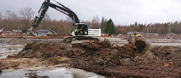 Bild på grävmaskin som arbetar med en saning av Åsbro vid sjön tisaren.