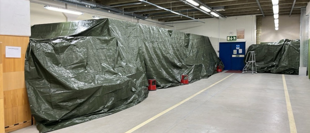 Bilden visar dokumentarkivet där plastpresenningar täcker delar av innehållet.