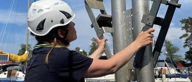 Kvinna i hjälm som håller i utrustning för provtagning av sediment i sjöar