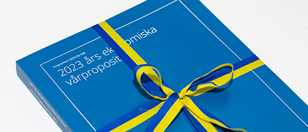 Foto på en bok med blått omslag och texten 2023 års ekonomiska vårproposition. Foto på en bok med blått omslag och texten 2023 års ekonomiska vårproposition.