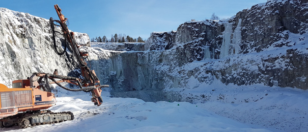 Foto av en gul borrigg i en bergtäkt på vintern. Foto av en gul borrigg i en bergtäkt på vintern.