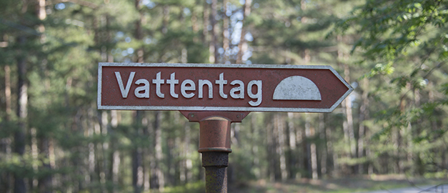 På bilden syns en brun skylt som det står vattentag på. På bilden syns en brun skylt som det står vattentag på.