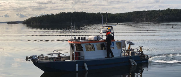 En mindre båt utför undersökning i vattnet. Foto. En mindre båt utför undersökning i vattnet. Foto.