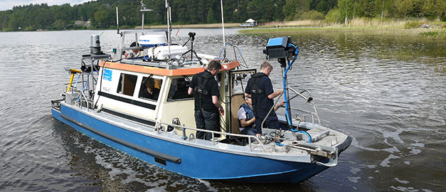 På bilden syns SGU:s båt Ugglan. På båten står några män som arbetar med provtagning av Fyrisån i Uppsala, Sverige. Foto. På bilden syns SGU:s båt Ugglan. På båten står några män som arbetar med provtagning av Fyrisån i Uppsala, Sverige. Foto.